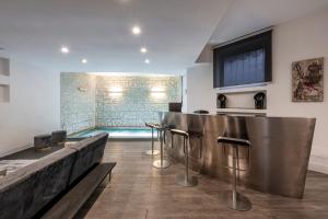 ミラノにあるDesign Apartment with private pool exclusive use - Stelvio 21のリビングルーム(プール付)、バー(スツール付)