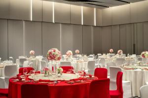 a room filled with tables and chairs with flowers on them at HUALUXE Shanghai Changfeng Park, an IHG Hotel in Shanghai