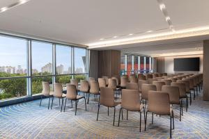 a conference room with chairs and a projection screen at HUALUXE Shanghai Changfeng Park by IHG in Shanghai +287 photos