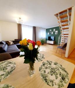 uma sala de estar com um vaso de flores sobre uma mesa em Ferienwohnung FüssenPur em Füssen