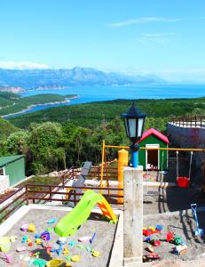 a play area with a playground with a slide at Apartments Villa Milna 1 in Budva