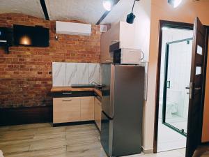 a kitchen with a refrigerator and a brick wall at Pokoje Jola in Drawsko Pomorskie +16 photos