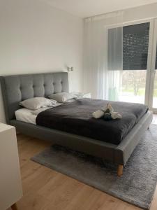 a large bed in a bedroom with a large window at Lela lakeside apartman a vizek szerelmeseinek in Balatonlelle