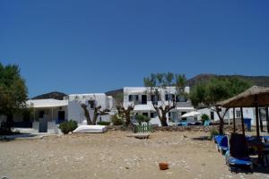 plaży z leżakami, parasolami i budynkami w obiekcie LEANDROS APARTMENTS w mieście Platis Gialos Sifnos
