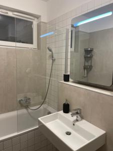 y baño con lavabo, ducha y espejo. en Lela lakeside apartman a vizek szerelmeseinek, en Balatonlelle