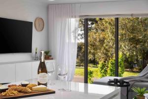 a kitchen with a bottle of wine and wine glasses at Izzys Retreat in Creswick