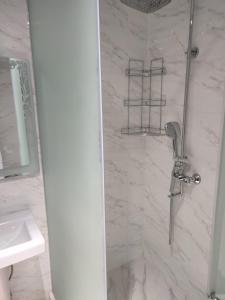 a shower in a bathroom with a white marble wall at "AIKO" Konak Otbasy in Shymkent