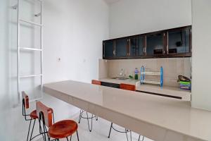 uma cozinha com um balcão longo e algumas cadeiras em OYO 92057 Reny Kost Syariah em Jambi