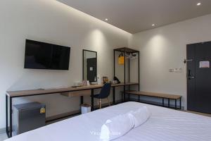 a bedroom with a bed and a desk and a television at Yello Block Hotel 