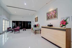 um lobby hospitalar com uma recepção e cadeiras em OYO 92057 Reny Kost Syariah em Jambi