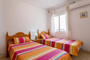 1 dormitorio con 2 camas y ventana en 3 Bedroom Holiday Villa Benani, en Puerto Marino