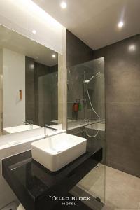 a bathroom with a white sink and a shower at Yello Block Hotel 