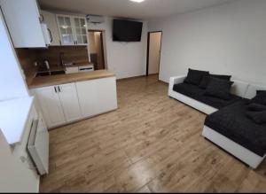 a living room with a couch and a kitchen at Apartmány u Sečského zámku in Seč