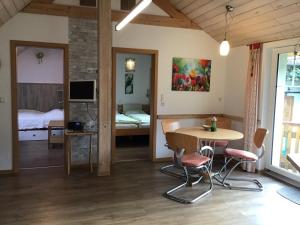 een kamer met een tafel en stoelen en een slaapkamer bij Ferienwohnung Holzheimer in Sandberg