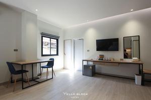 a living room with a table and chairs and a television at Yello Block Hotel 