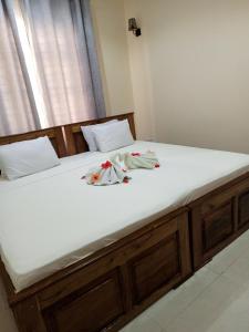 a large bed with white sheets and dolls on it at Kendwa Cool and Calm Hotel limited in Kendwa
