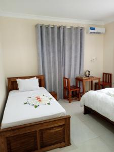 a bedroom with two beds and a table and chairs at Kendwa Cool and Calm Hotel limited in Kendwa
