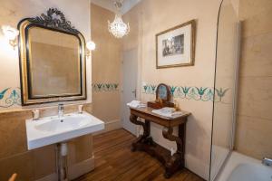 e bagno con lavandino, specchio e vasca. di L'Hotel de Panette, Un exceptionnel château en ville a Bourges