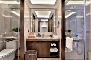 W łazience znajduje się umywalka, toaleta i lustro. w obiekcie 银都酒店 Yandoo Hotel w mieście Yiwu