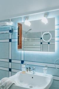 a bathroom with a white sink and a mirror at Kalavrita Krinides Apartment and Attics in Kalavrita