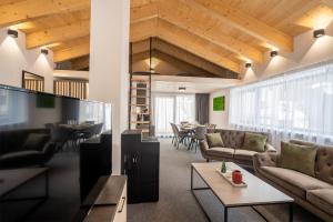 una sala de estar con sofás, mesas y sillas en Chalet Malino - Apartments en Ružomberok