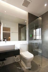 a bathroom with a toilet and a sink and a shower at Yello Block Hotel 