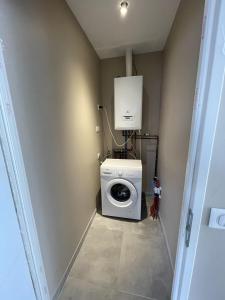 a laundry room with a washer and a washing machine at Une pause à la Hume in Gujan-Mestras