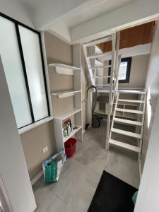 a small room with bunk beds and a staircase at Une pause à la Hume in Gujan-Mestras