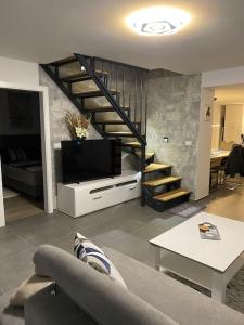 a living room with a tv and a staircase at Apartment MM22 in Peroj