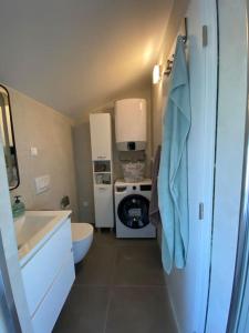 un piccolo bagno con lavandino e lavatrice di Apartment MM22 a Peroj
