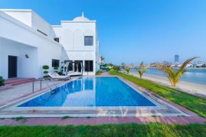 a swimming pool in the backyard of a house with the water at Maison Privee - 5 Stars Villa with Private Pool or Beach on Palm Jumeirah in Dubai