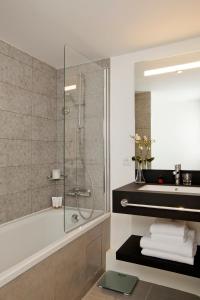 a bathroom with a shower and a tub and a sink at Residhome Puteaux La défense in Puteaux