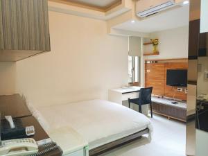 a bedroom with a bed and a desk with a computer at Tianmu Star Urban Living in Taipei