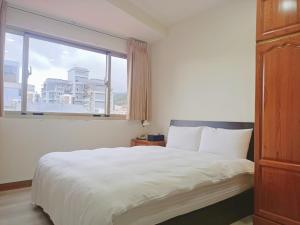 una camera da letto con un letto grande con una grande finestra di Tianmu Star Urban Living a Taipei