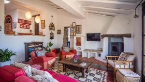 sala de estar con muebles de color rojo y chimenea en Casa Belmonte Alcaucín by Ruralidays, en Alcaucín