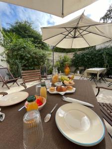 a table with plates of food and an umbrella at BnB FICO in Lecce