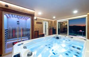 uma grande banheira num quarto com uma grande janela em Bregec Tiny House and Wellness em Varaždinske Toplice