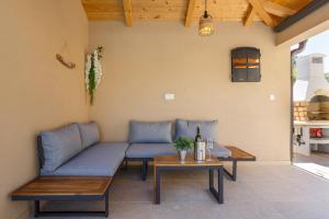 eine Terrasse mit blauen Sofas und einem Tisch in der Unterkunft Villa MONICA with private pool in Risika