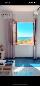 Cette chambre dispose d'une grande fenêtre offrant une vue sur l'océan. dans l'établissement Villa “La Giummarra” - Scivolo di Cornino, à Custonaci