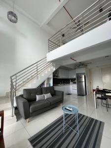 Yenni Duplex @ DeCentrum, Kajang في سيردانغ: غرفة معيشة مع أريكة وطاولة