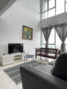 a living room with a couch and a tv at Yenni Duplex @ DeCentrum, Kajang in Serdang