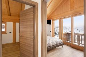 a bedroom with a bed and a large window at Plaz in Livigno