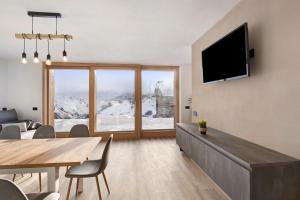 a living room with a television and a table and chairs at Plaz in Livigno