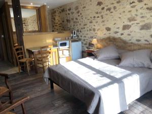 ein Schlafzimmer mit einem Bett und eine Küche mit einem Tisch in der Unterkunft Maison d'hôtes " Ecuries de St maurice" in Lacapelle-Marival