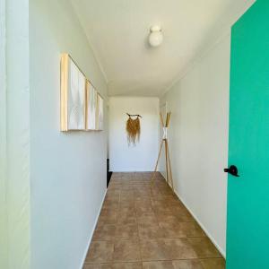 a hallway with white walls and a tiled floor at A Wave From It All in Torquay