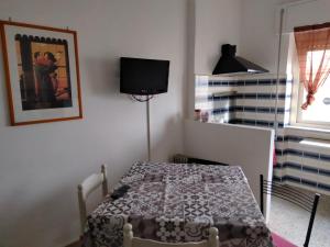a bedroom with a table and a television in it at Casa al mare in Anzio