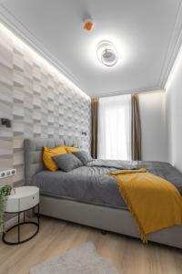 sypialnia z dużym łóżkiem z żółtymi poduszkami w obiekcie K46 Residence w Budapeszcie
