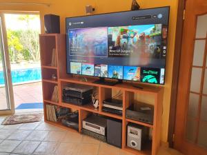 TV de pantalla plana en un centro de entretenimiento en Oceanfront Villa - 8 rooms, 2 kitchens with pool, billiard table and Beach-Volleyball Court, en Carvoeiro