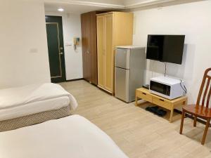 台北市にあるTianmu Star Urban Livingのベッド2台、テレビ、キッチンが備わる客室です。