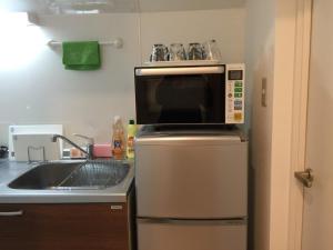 een keuken met een magnetron en een koelkast bij Isshuku Ryokan Asakusabashi - Vacation STAY 17363v in Tokyo